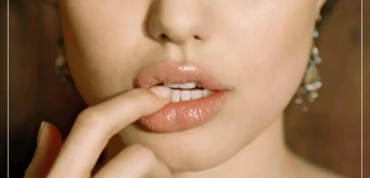 Gros plan d'une femme touchant sa lèvre inférieure, illustrant un bouton de fièvre ou herpès labial. Image pour l'article sur la prévention et le traitement des récidives de l'herpès labial sur Le Bord Libre