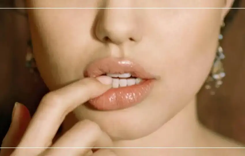 Gros plan d'une femme touchant sa lèvre inférieure, illustrant un bouton de fièvre ou herpès labial. Image pour l'article sur la prévention et le traitement des récidives de l'herpès labial sur Le Bord Libre